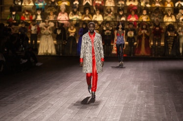 A model in a red shirt and trousers and white-black coat at the Louis Vuitton fall 2020 show