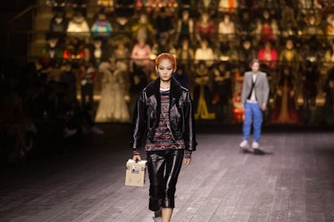 A model walking in a black jacket and skirt and a brown shirt at the Louis Vuitton fall 2020 show