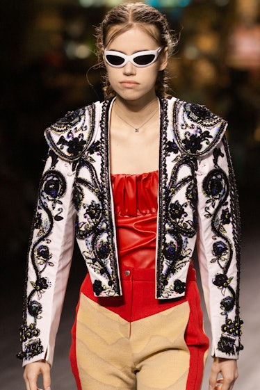 A model walking in a red corset, black-white jacket and beige-red pants at the Louis Vuitton fall 20...