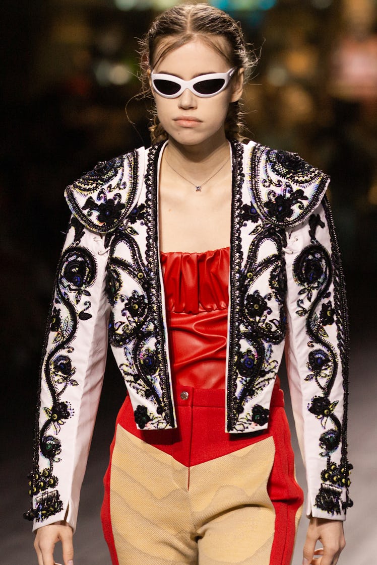 A model walking in a red corset, black-white jacket and beige-red pants at the Louis Vuitton fall 20...