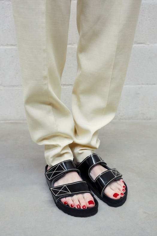 Model standing in trousers and black Proenza Schouler’s Birkenstock Collab slippers
