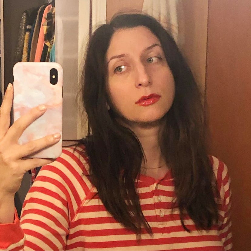 Chelsea Peretti taking a mirror selfie in a red-white striped shirt