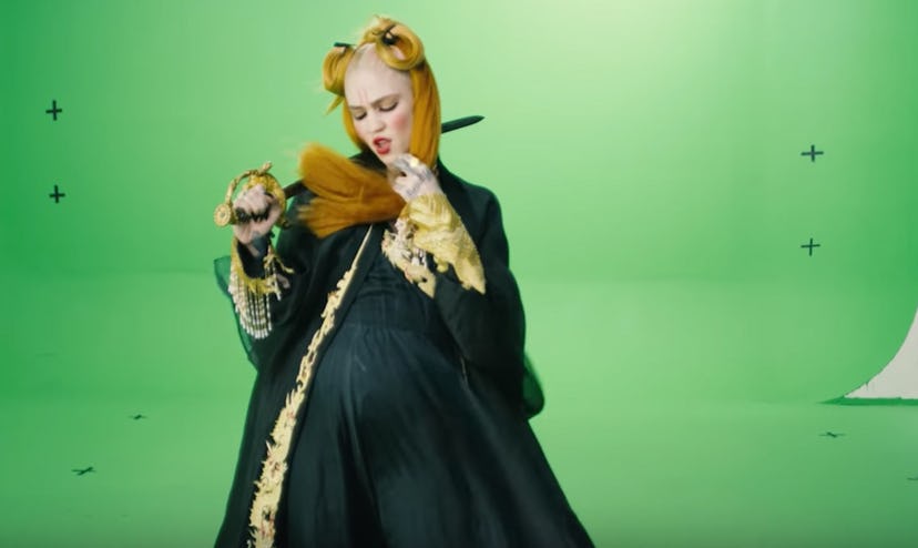 Grimes in front of a green screen.