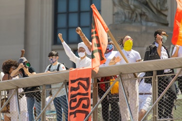 Brooklyn Liberation protestors holding orange "Rise" flags