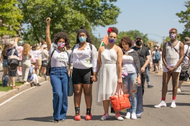 Four Brooklyn Liberation attendants posing together for a photo while wearing white outfits