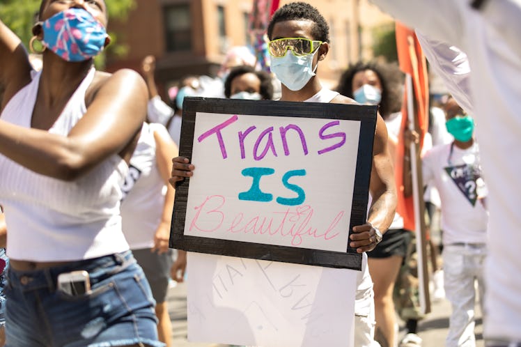 Brooklyn Liberation attendant holding a white poster with "trans is beautiful" text