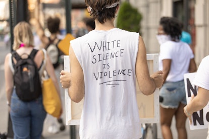 A person wearing a "white silence is violence" t-shirt