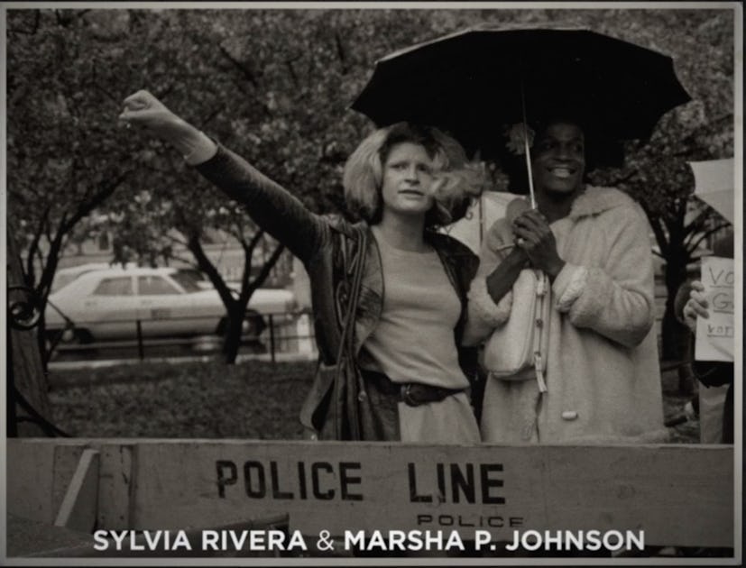 Sylvia Rivera and Marsha P Johnson standing with an umbrella behind a sign that says "police line"