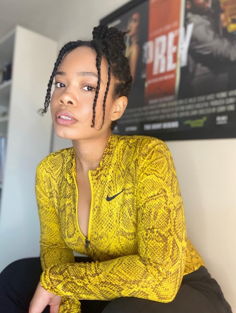 Weruche Opia in a yellow snakeskin-patterned Nike workout jacket and her hair up 