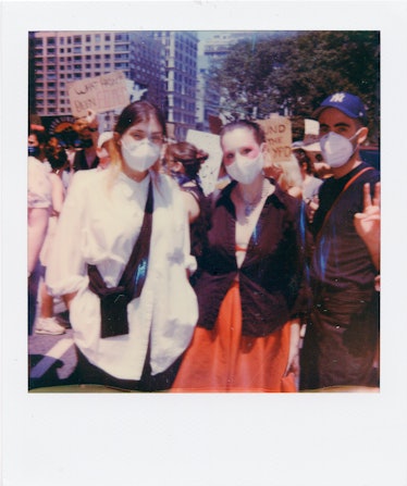A polaroid shot of three people with white face masks at the New York City Pride March