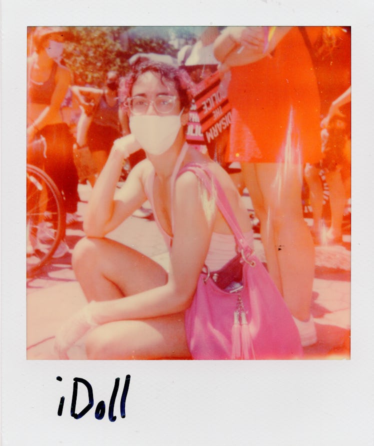 A polaroid shot of a person squatting and posing at the New York City Pride March with the text 'iDo...