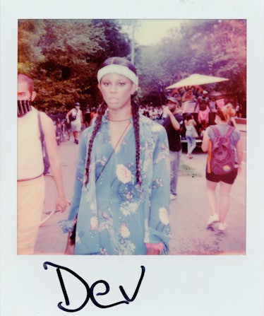 A person in a polaroid shot in a blue outfit at the New York City Pride March with the text 'Dev'