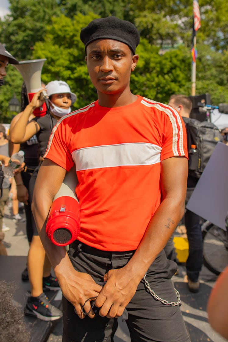 A man in a white-orange shirt, black trousers and a black beret on the 4th of July