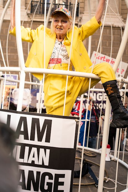 Vivienne Westwood climbing a cage