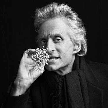 Michael Douglas, star of The Kominsky Method, posing for a photo while holding a tiny white branch w...