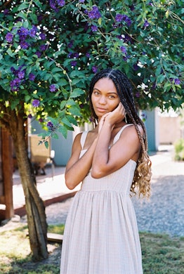 Green girl Leah Thomas posing for a photo in a white dress 