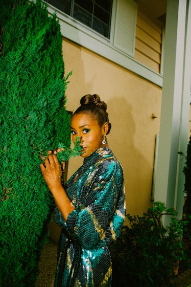 Issa Rae posing while wearing a blue sequined gown