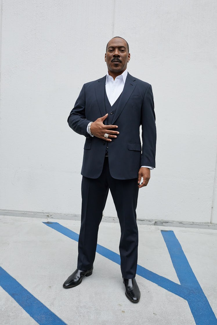 Eddie Murphy posing for a photo while wearing a formal suit