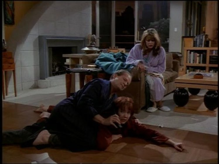 Frasier Crane and Bebe Glazer fighting over the telephone on the floor and Daphne Moon sitting on th...