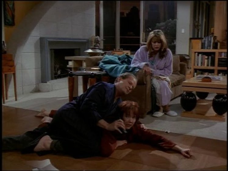 Frasier Crane and Bebe Glazer fighting over the telephone on the floor and Daphne Moon sitting on th...