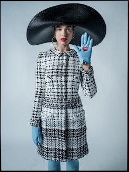 Dua Lipa posing in a Chanel Haute Couture tweed dress, Eric Javits hat, and Paula Rowan gloves.