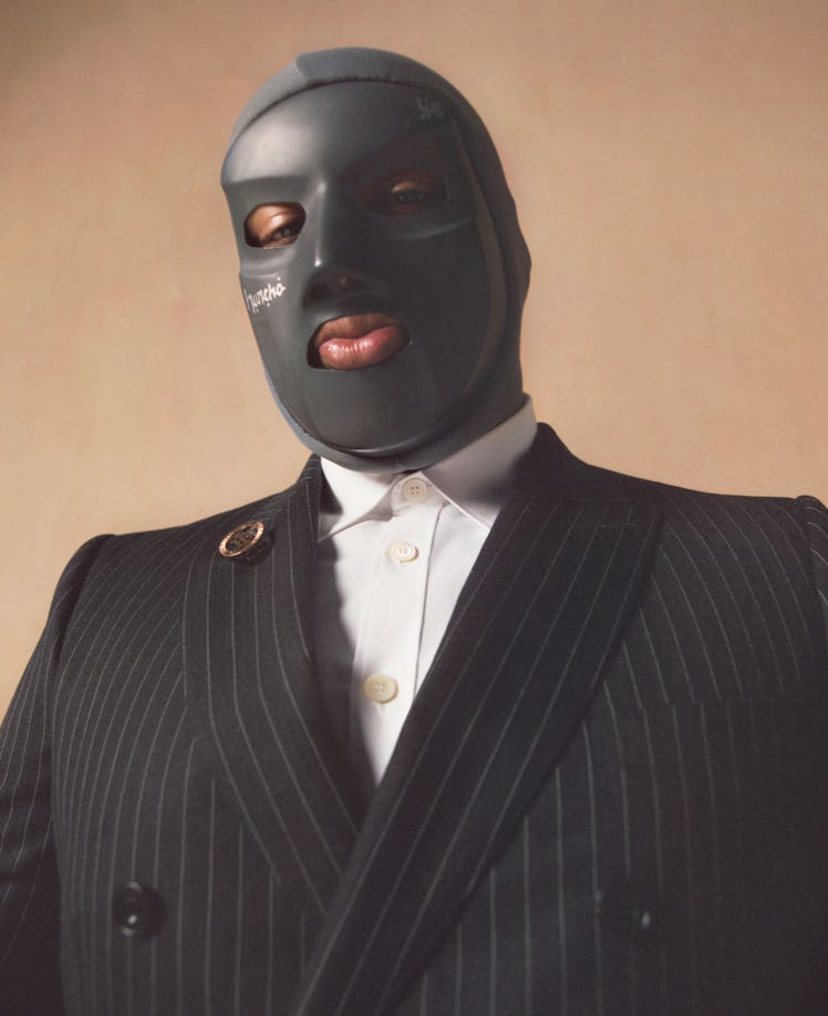 M Huncho wearing his custom-made mask and Burberry suit