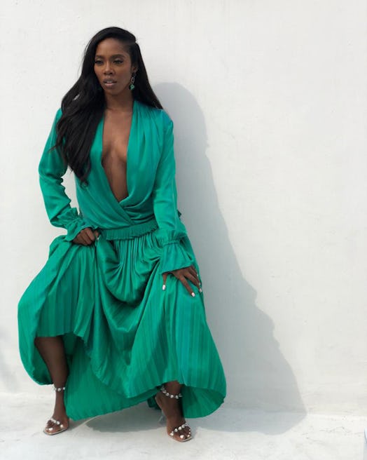Tiwa Savage posing for a photo in a green dress 
