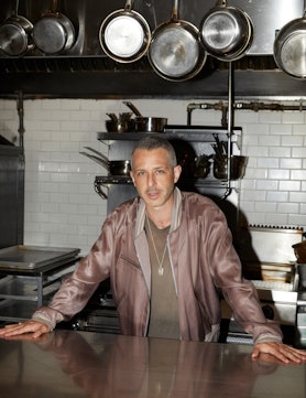 Succession’s Jeremy Strong in a khaki shirt and a mauve satin bomber jacket in a kitchen
