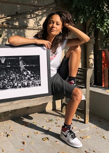 Thandie Newton sitting on a bench and posing next to a framed black-and-white photograph