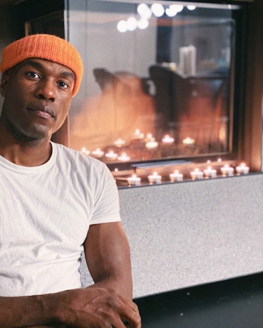 Watchmen’s Yahya Abdul-Mateen II posing in a white shirt and orange cap