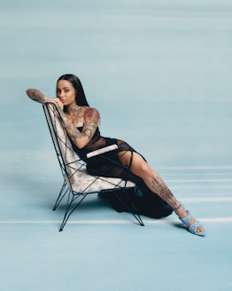 A photograph by Micaiah Carter of Kehlani in a black dress posing on a chair