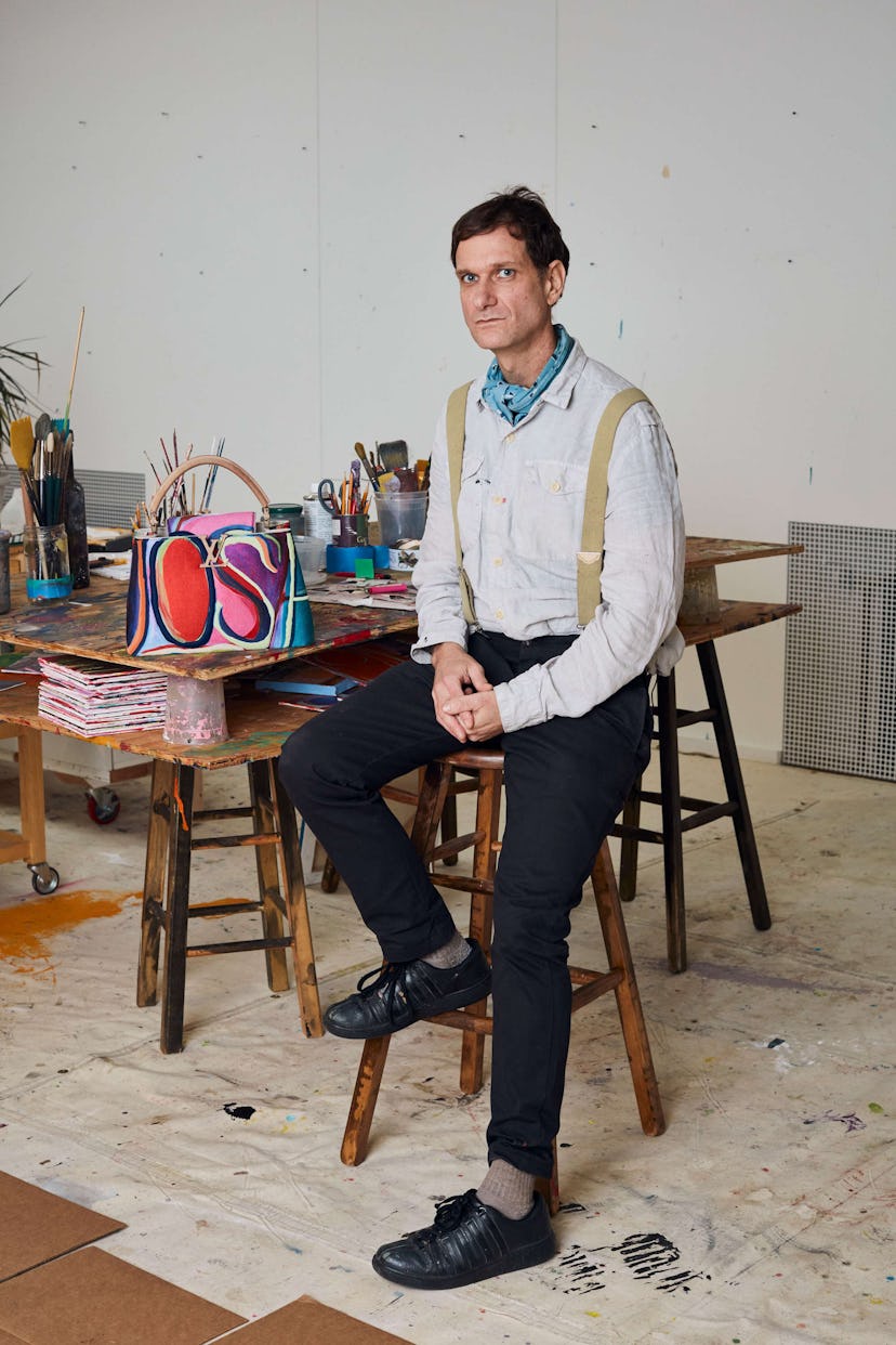 Josh Smith sitting next to a bag on which he applied a technicolor touch in various colors