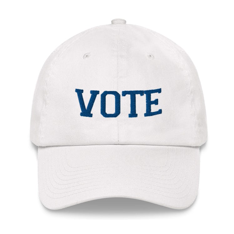A white Vote Cap with blue embroidered text 'VOTE'
