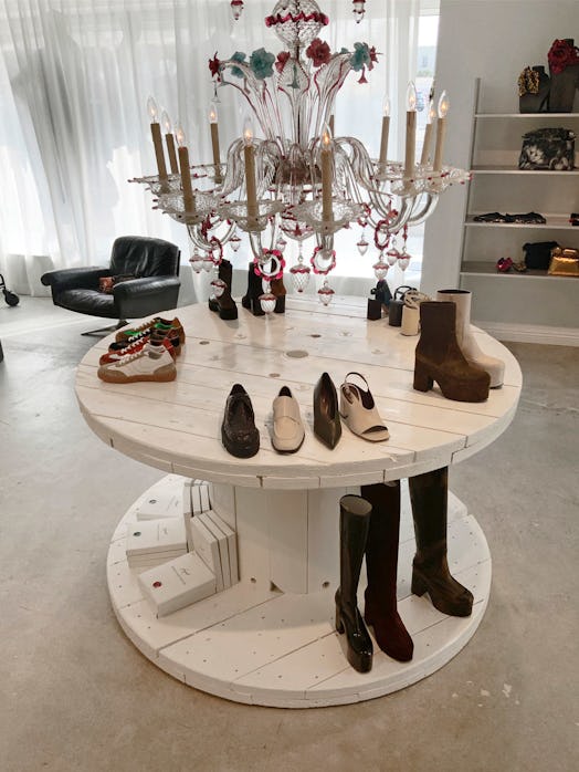 The inside of the Dries Van Noten store with shoes laid out on a round table on two levels
