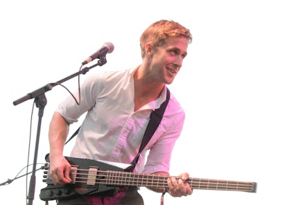 Ryan Gosling holds a bass guitar.