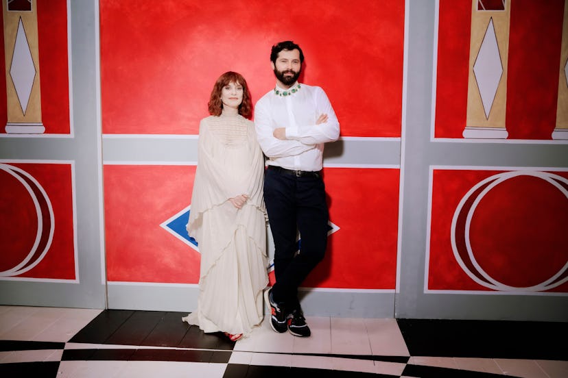 Gherardo Felloni in a dress shirt and pants and Isabelle Huppert in a beige gown posing leaned again...