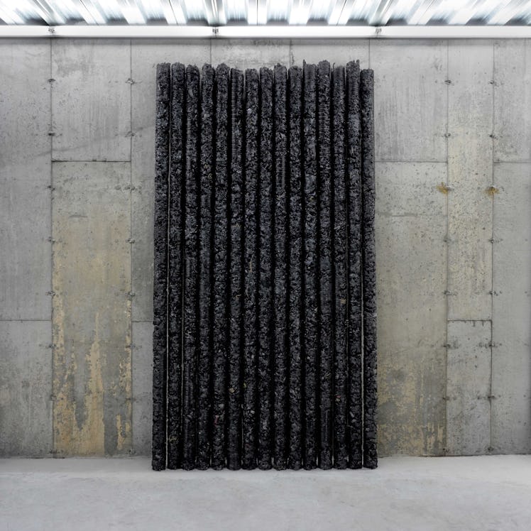 Sculpture consisted of long black sticks leaned against a wall
