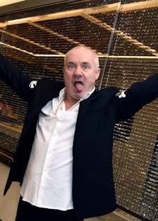 Damien Hirst with his arms outstretched