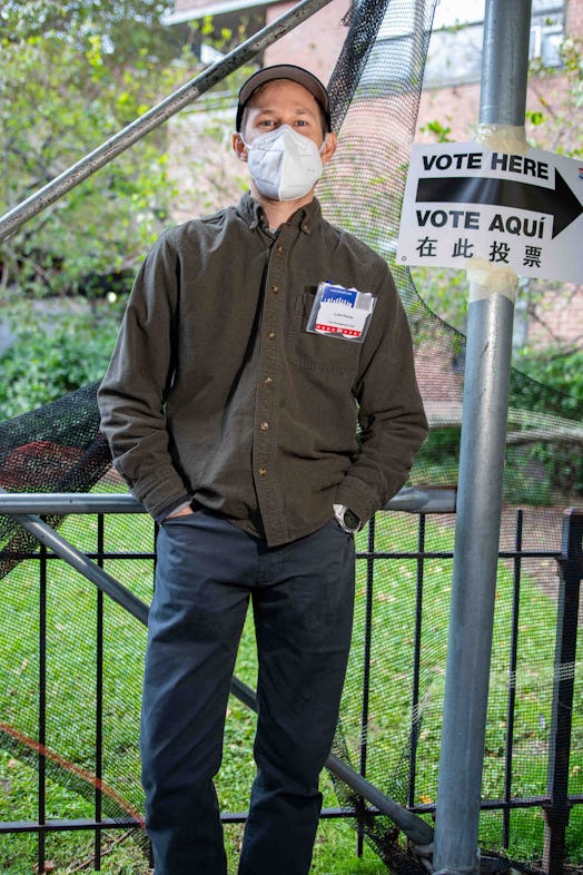 Luke Pauley standing next to a "Vote Here" sign with an arrow on it 