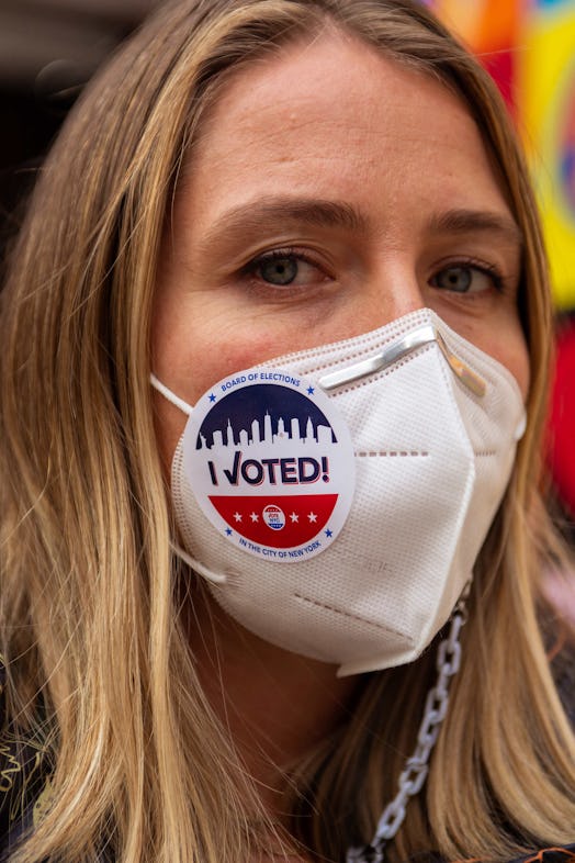 A closeup of Chrissy Nichol's face with an "I Voted" sticker on her white face mask 