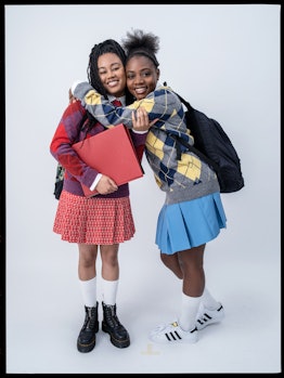 Lauren-Joy Williams and Danielle Vitalis in checkered sweaters, skirts, high socks, and backpacks, h...