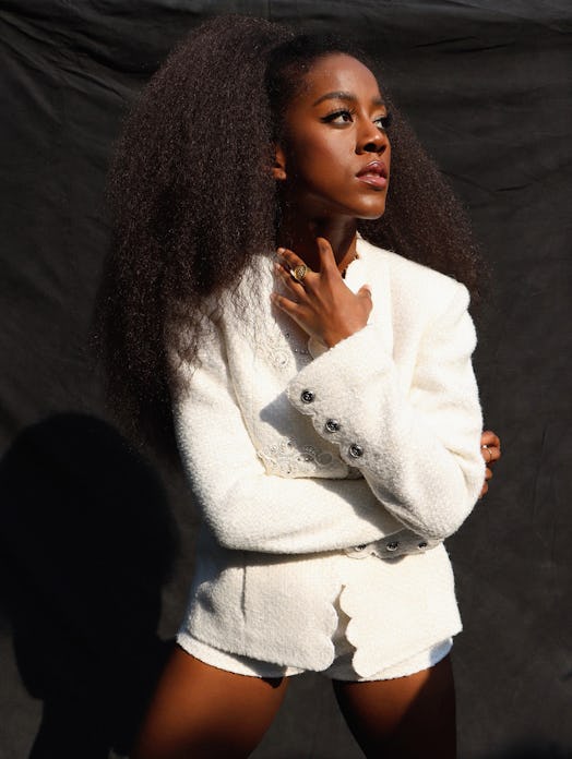 Tomi Adeyemi wearing a white jacket and shorts while posing for a photo
