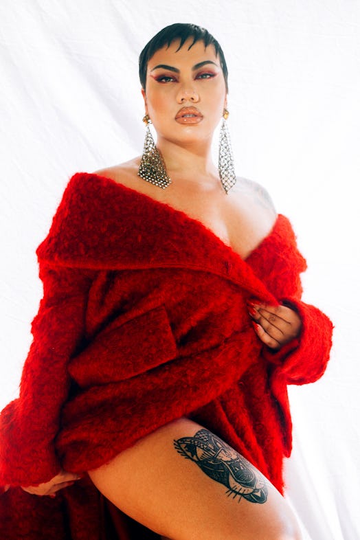 Parris Goebel posing in a red Miu Miu coat showing her panther tattoo