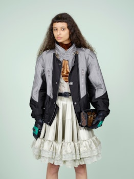 A model wearing a black-grey jacket and a beige skirt from Fall 2020