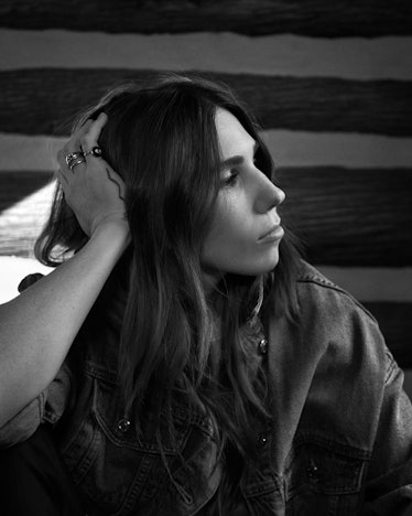 A black-and-white portrait of Zosia Mamet with her hand on her head looking to the left side