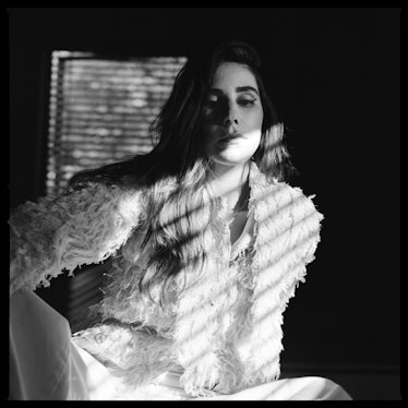 A black-and-white portrait of Zosia Mamet in a feather jacket 