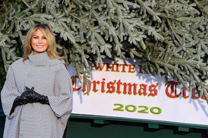 Melania Trump smiling next to a Christmas tree