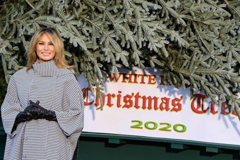 Melania Trump smiling next to a Christmas tree