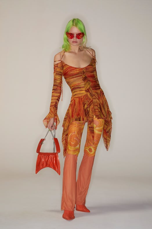 A model posing in an orange look by Charlotte Knowles