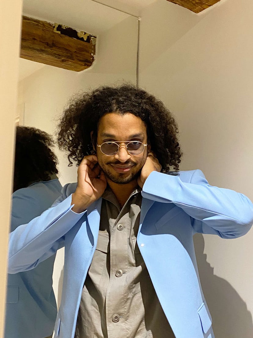 David Zilber in a light blue blazer and grey button-up with circular sunglasses on